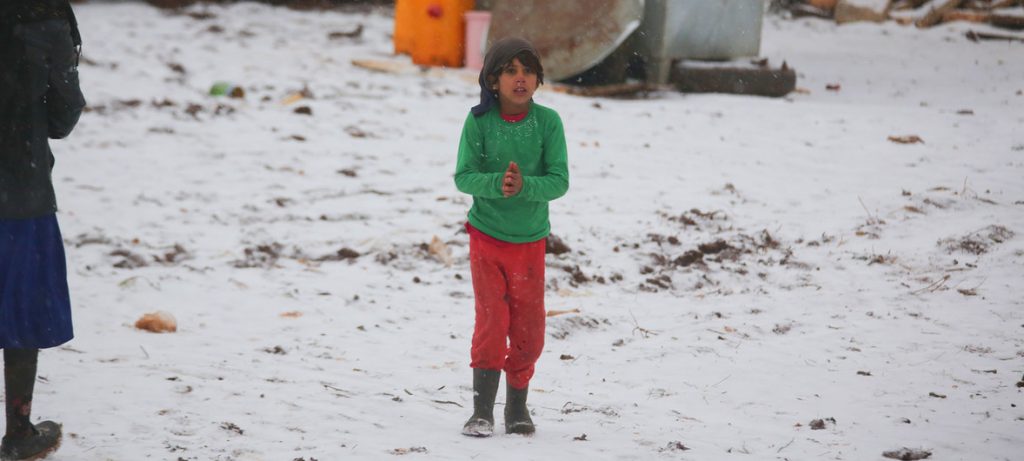 Criança caminha na neve em um assentamento informal recentemente estabelecido que continua a receber famílias deslocadas do sul de Idlib e das províncias rurais de Alepo, no noroeste da Síria. Foto: UNICEF/Baker Kasem