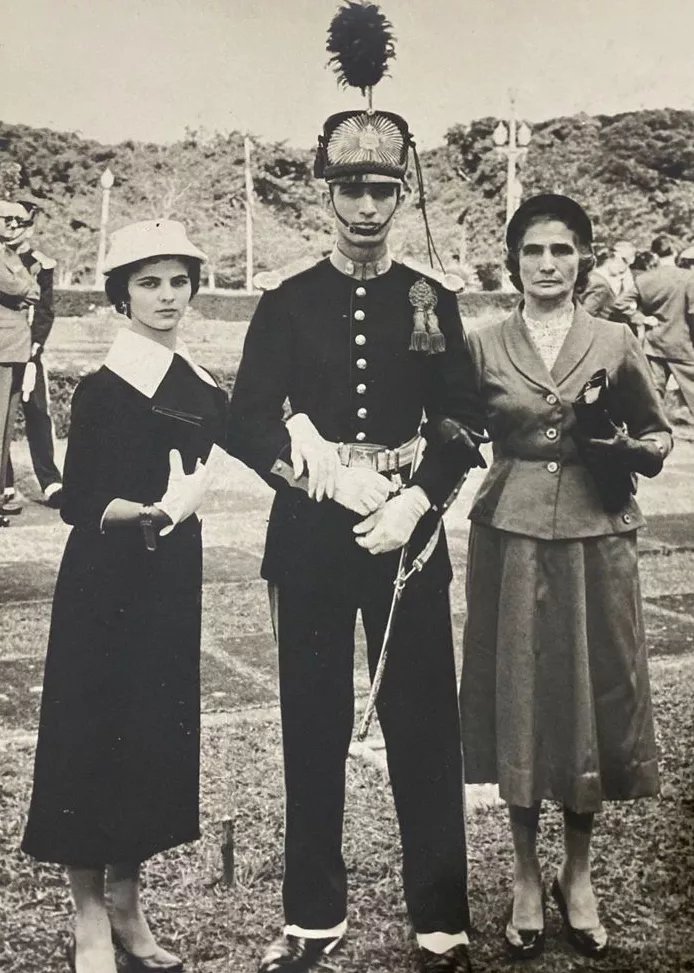 Lamarca com vestimenta típica do exército ao lado de duas mulheres