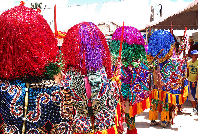 Foto mostra desfile tradicional de maracatu nas ruas de Olinda