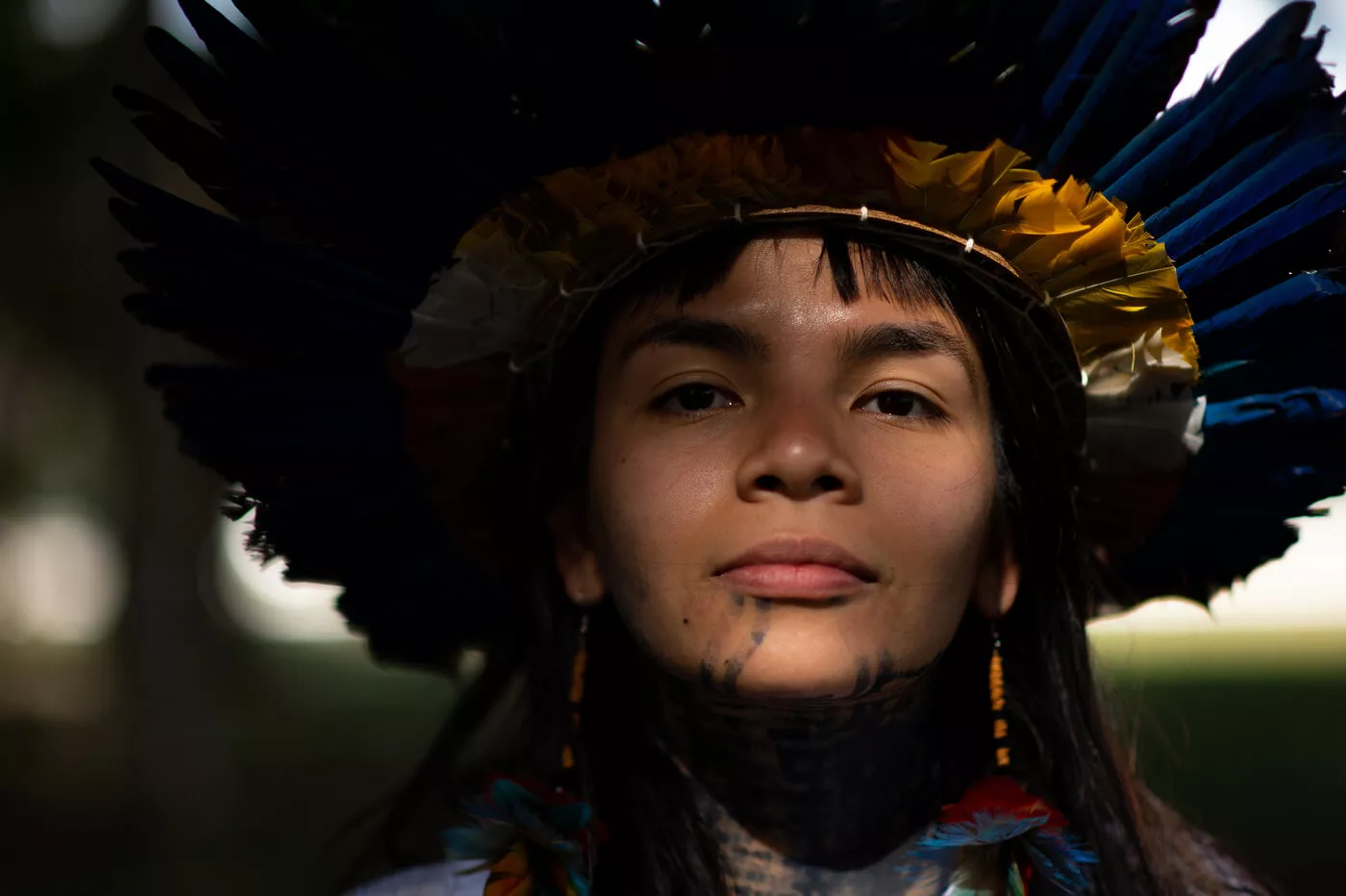 Txai Suruí: “Não estão queimando só a Amazônia, estão queimando as pessoas de lá também” 11 Txai é uma jovem indígena com cabelos e olhos castanhos. Ela usa um cocar na cabeça, brinco de pena nas orelhas e tem pintura étnica no rosto e pescoço
